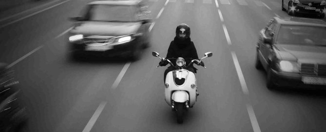 person riding a moped on a busy road