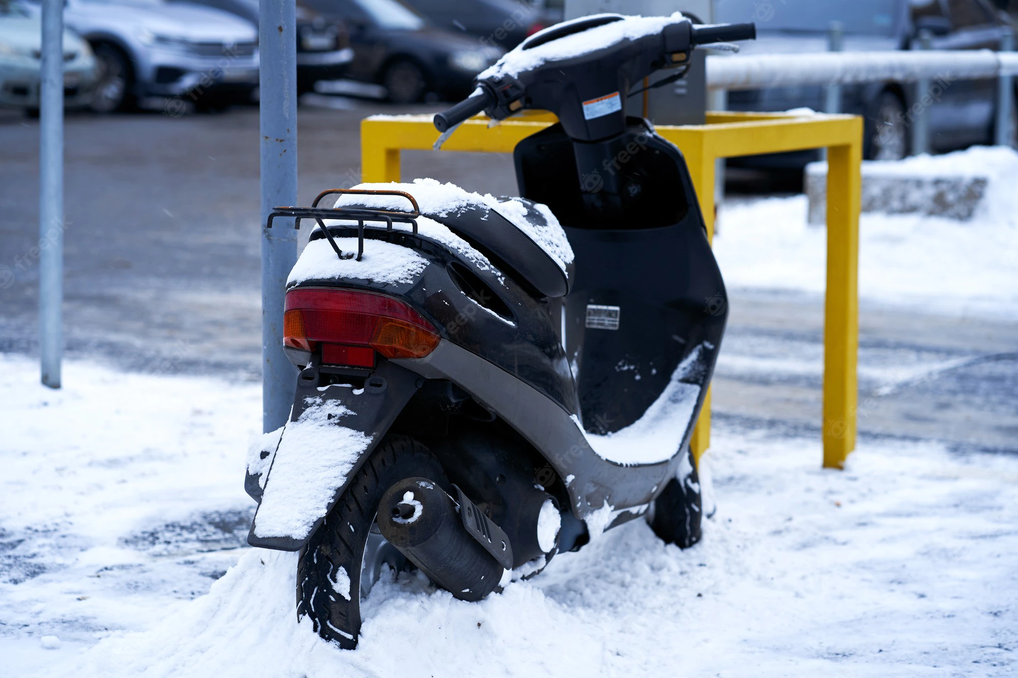 petrol driven scooter parked on the edge of a street in the snow