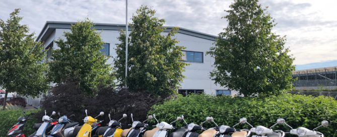 A variety of scooters lined up in a row at Silverstone.