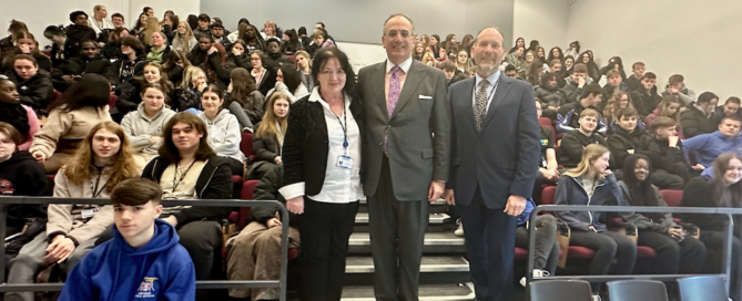 Michael Ellis MP stood in front of a group of Northampton College students with principal Pat Brennan-Barrett and public services curriculum manager Michael Colbourne